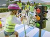 Des écoliers s’entraînent à passer un feu tricolore pendant un cours de conduite cycliste