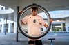 Un élève tient la roue d'un vélo dans sa main - il va probablement le réparer.